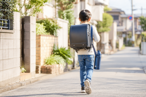 1リットル水筒を持って登校する小学生