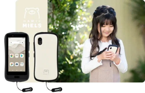 日本の小学生の女の子が見守りスマホ端末を操作しながら安心して使い方を確認している様子（Hamicイメージ）