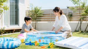 家庭用プールの準備をする小学生親子