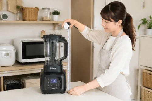 キッチンで大容量ミキサーのサイズを測り、設置スペースを確認する日本人ママの様子